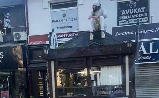 Büfesinin üzerine çıkıp kendini zincirledi